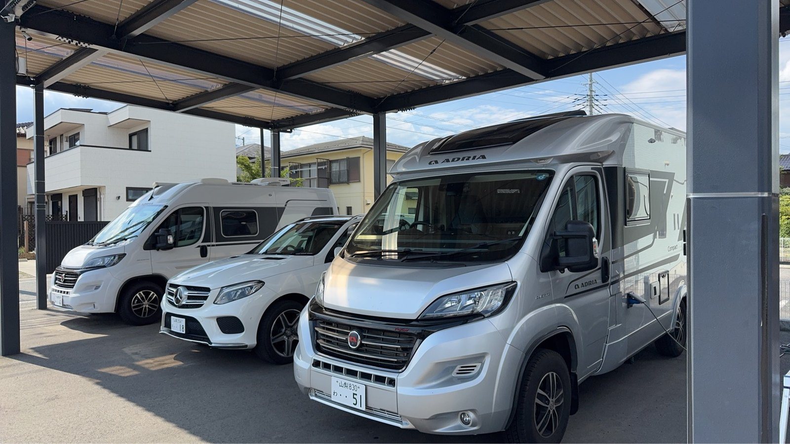 屋根付きスペースに並ぶADRIAなどのキャンピングカー
